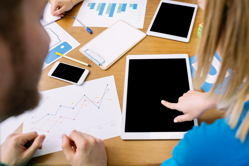 man-looking-woman-touching-digital-tablet-screen-table